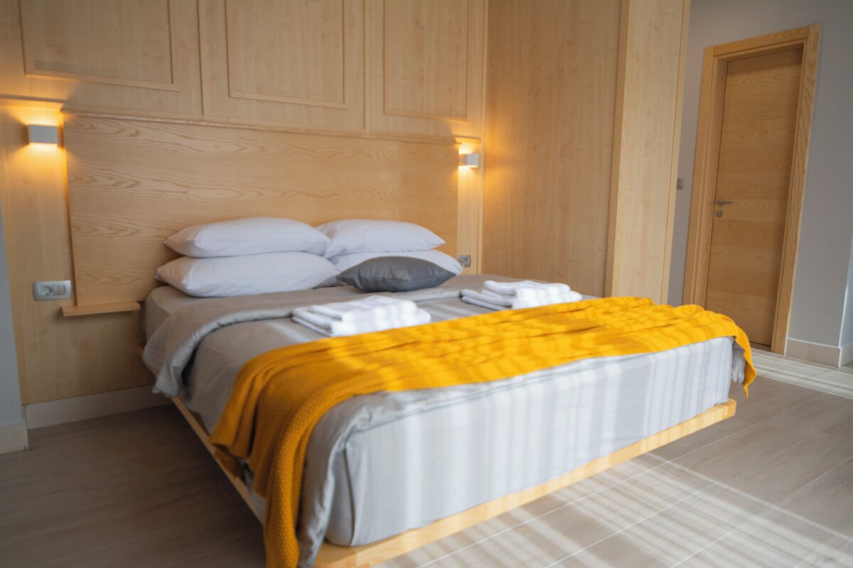 Une chambre à coucher avec un lit, des oreillers et une couverture.