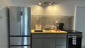 Een moderne keuken met roestvrijstalen apparatuur, een houten aanrecht en een betegelde spatwand.