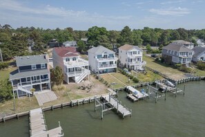 A waterfront property with multiple two-story houses, a dock, and a grassy area.