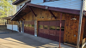 A wooden garage with a metal roof and a concrete driveway. - Lake front suite on very desirable lake in Gwinn, Mi. Year round activities. (Gwinn)