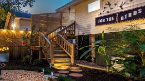 A wooden staircase leading to a house with a sign that reads "For the Birds."