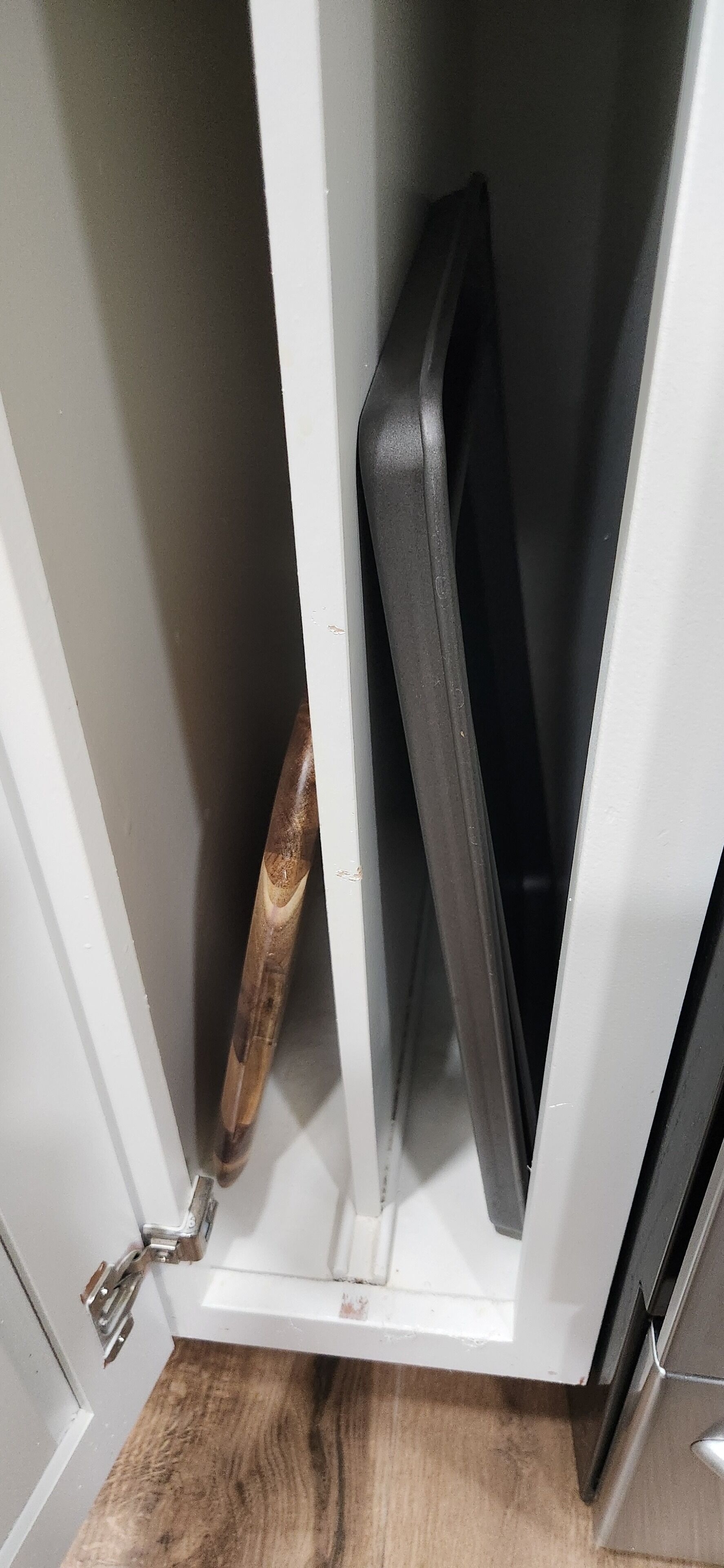 Eine weiße Tür mit einem Holzgriff und einem Metallriegel.