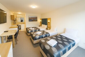 A hotel room with two beds, a desk, and a chair. - Eildon Lake Motel (Eildon)