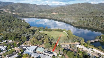 Vista aerea di una proprietà sul lago con un grande edificio, una strada e vegetazione circostante.