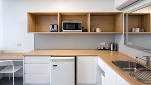 A modern kitchen with a microwave, coffee maker, and a small refrigerator. - Eildon Lake Motel (Eildon)
