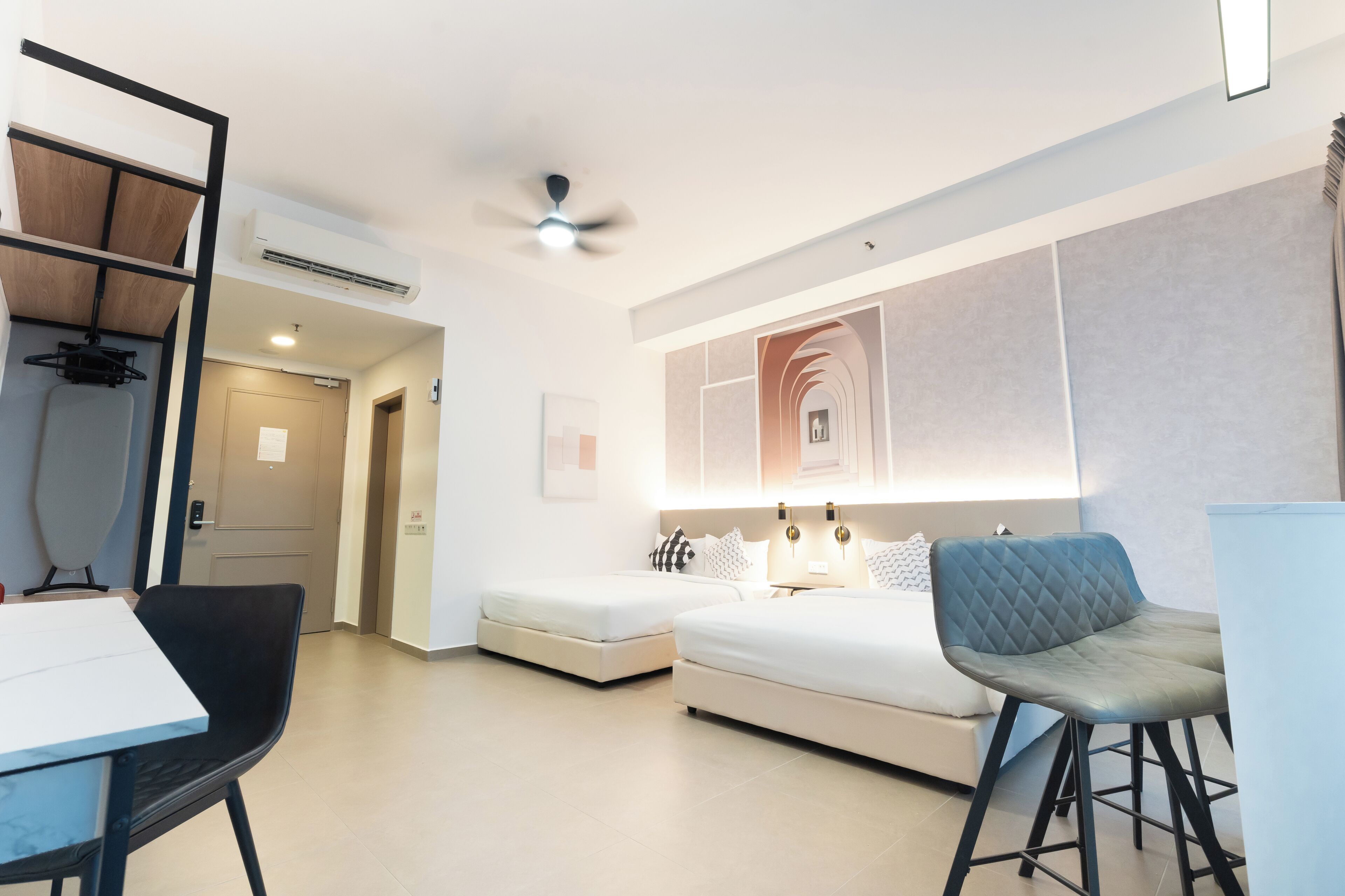 Una habitación de hotel moderna con una cama, un escritorio, una silla y un ventilador de techo.