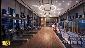 Un gimnasio moderno con cintas de correr, máquinas de pesas y un espejo grande.