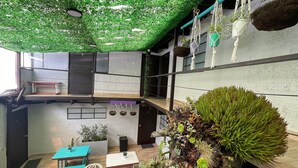 A modern interior with a green ceiling, wooden furniture, and various plants. - Súper Apartamento central Casa Colonial (Bogotá)