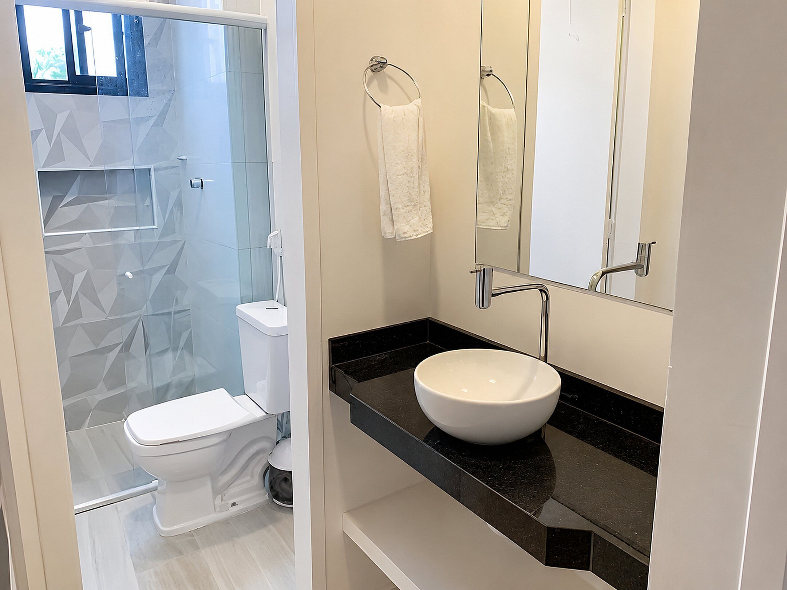 Un baño moderno con inodoro, lavabo y zona de ducha.