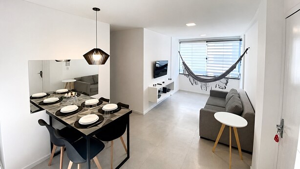 Un espace de vie moderne comprenant un coin repas, un canapé, un hamac et un téléviseur.
