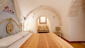 Ein Schlafzimmer mit einem Bett, einem Sessel, einem Nachttisch und einem Fenster mit Blick.