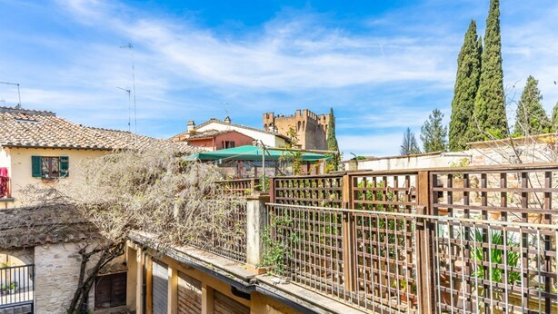 A residential area with a castle-like structure, a wooden fence, and a clear blue sky.