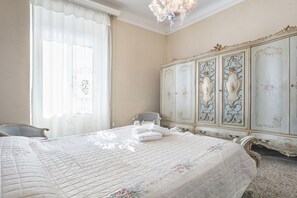 Quarto com uma cama grande, um guarda-roupa e uma cadeira.
