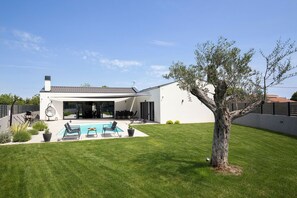 Relax and entertain in the spacious backyard with a swimming pool and covered patio area.