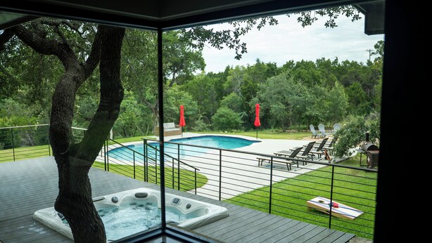 Ein Whirlpoolbereich mit Pool, Gartenmöbeln und Blick auf die umliegende Natur.