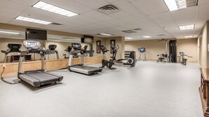A gym with treadmills, elliptical machines, and a stationary bike.