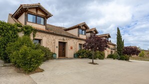 Una casa in pietra a due piani con tetto in tegole, un portone e un piccolo portico.