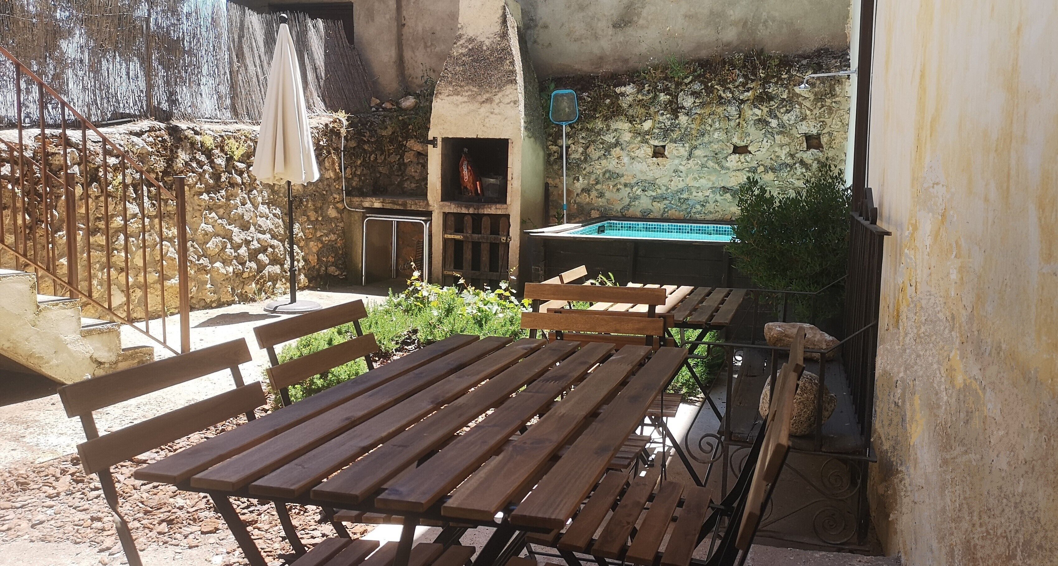 An outdoor patio with wooden benches and a stone wall.