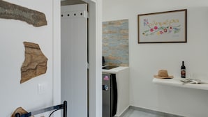 Ein Badezimmer mit Dusche, Handtuchhalter, einem gerahmten Kunstwerk und einer Flasche auf einem Regal.