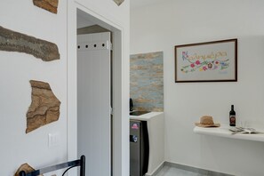 A bathroom with a shower, a towel rack, a framed artwork, and a bottle on a shelf.