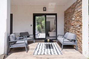 A patio with two grey sofas, a black coffee table, and a patterned rug. - Escape and serenity at Studio Le Partegal with shared pool, Wi-Fi and air conditioning (La Valette-du-Var)