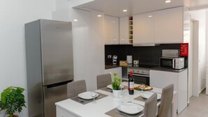 Una cocina moderna con microondas, horno y máquina de café integrados.
