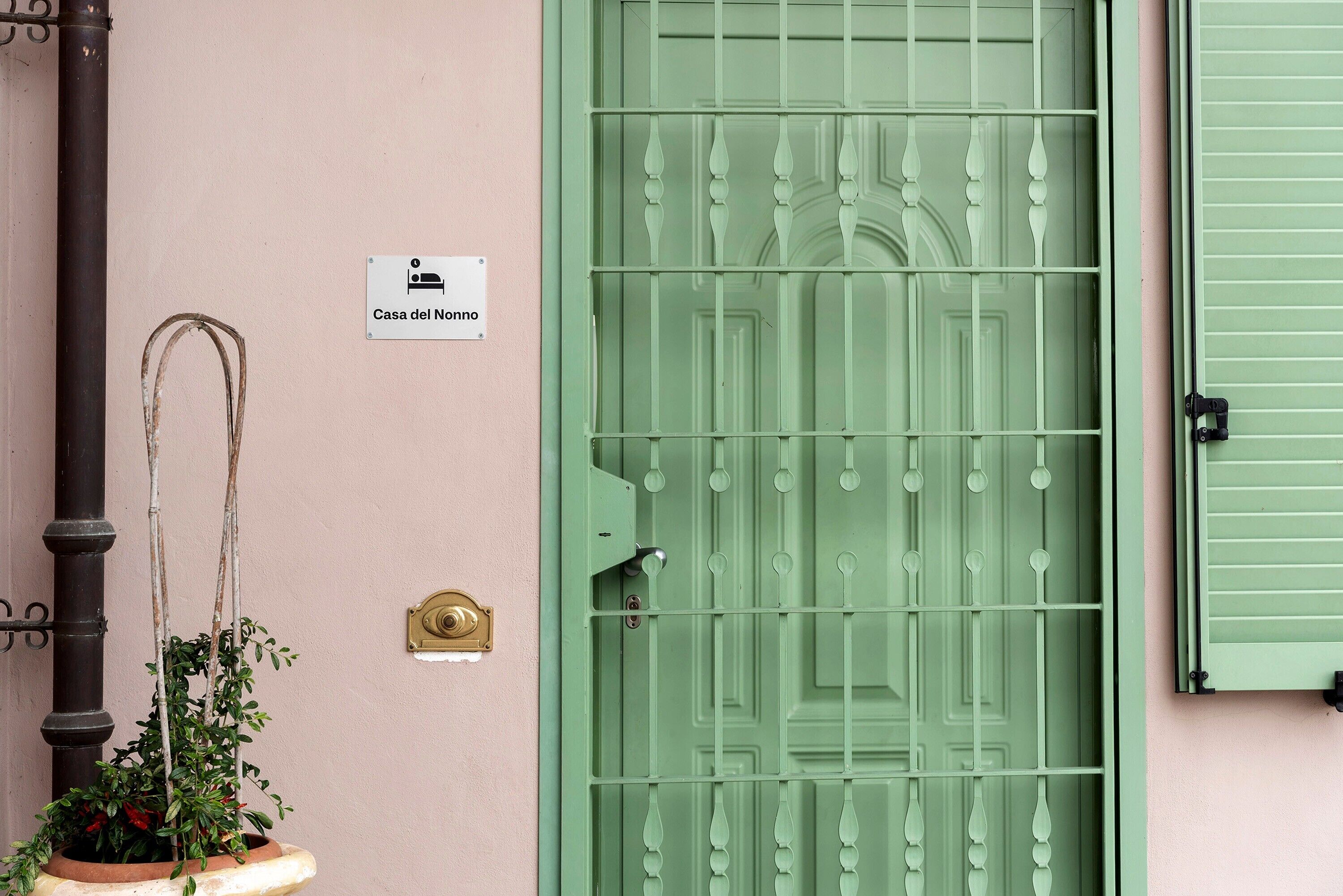 Eine grüne Tür mit einem Schild, das 'Casa del Nonno' zeigt, und einem Messing-Glockenschild.