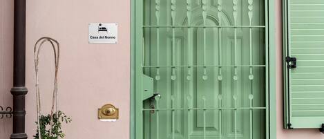 Una puerta verde con un letrero que dice 'Casa del Nonno' y un timbre de latón.