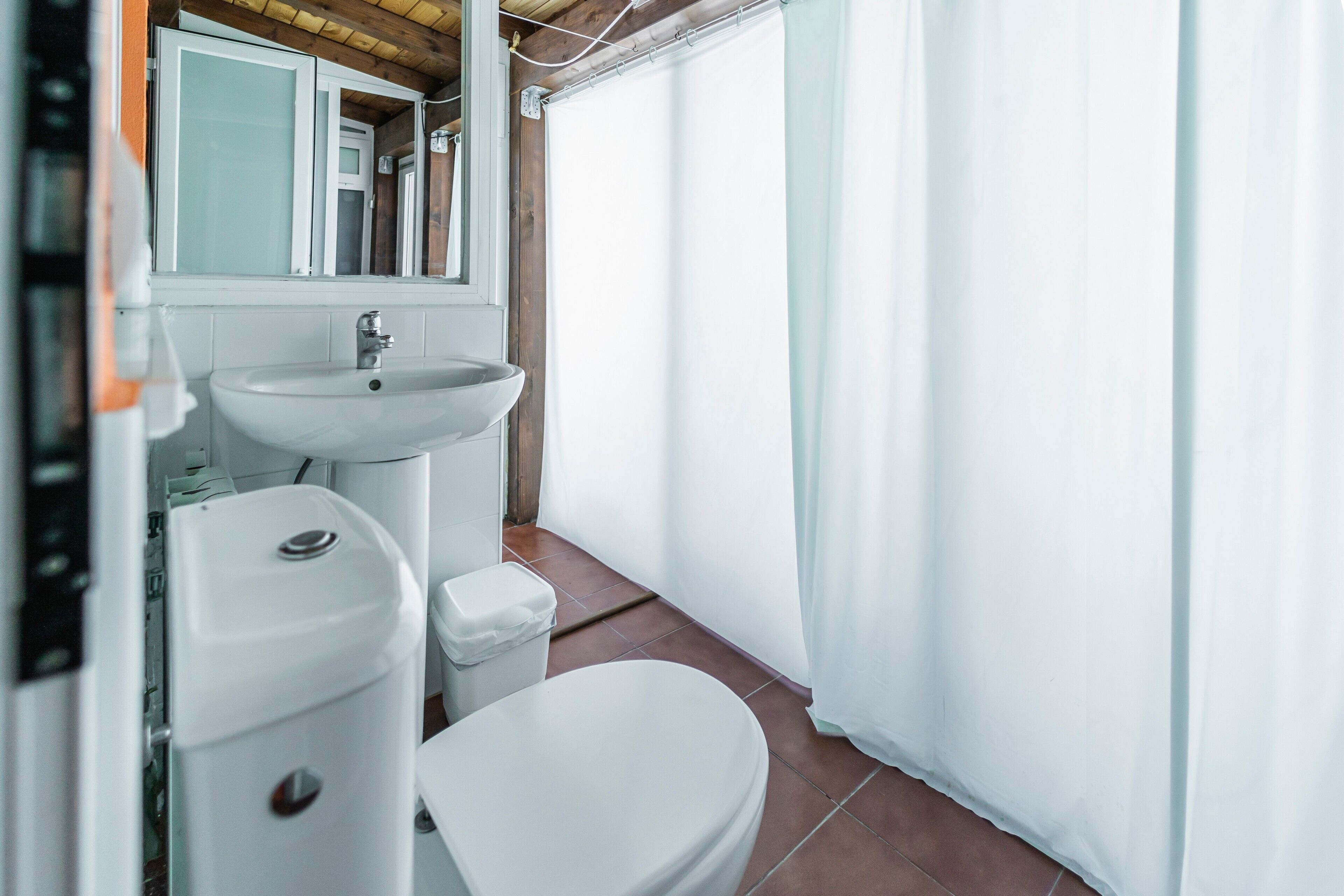 Een badkamer met een wastafel, toilet en douchegordijn.