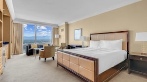Habitación de hotel con una cama grande, un escritorio, una silla y vistas a la ciudad.