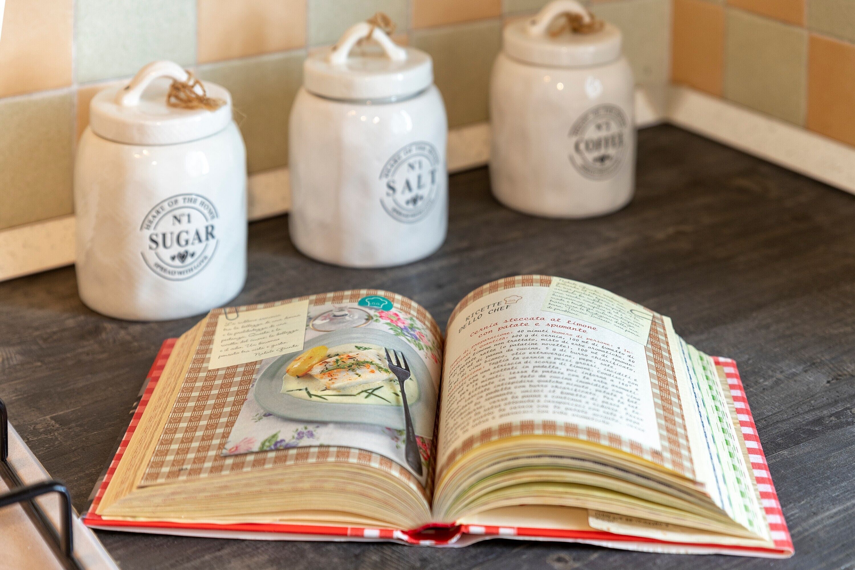 An open cookbook with a fork on top, placed on a wooden surface.