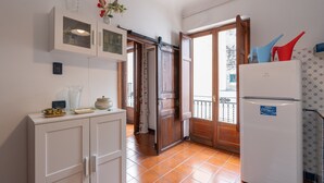 A kitchen with a refrigerator, cabinets, and a window with a view. - Apartment 'Antiche Scale' with Mountain View, Wi-Fi and Air Conditioning (Castellammare del Golfo)