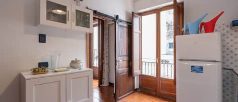 Una cocina con refrigerador, armarios y ventana con vista.