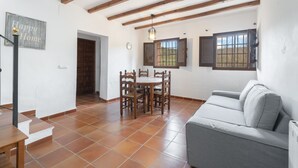A dining area with a table and chairs, a sofa, a staircase, and a 'Happy Home' sign.
