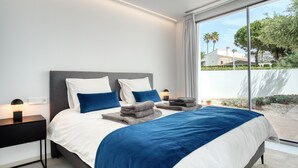 A modern bedroom with a large bed, bedside tables, and a view of the outdoors. - Villa 'Azul' with Mountain View, Wi-Fi and Air Conditioning (Teulada)