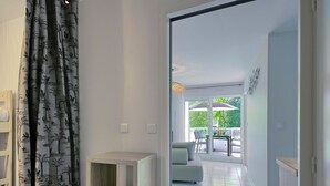 Ein modernes Wohnzimmer mit einer Couch, einem Couchtisch und einem Essbereich mit Stühlen und einem Sonnenschirm.
