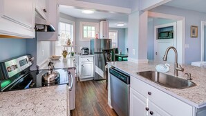 Una cocina moderna con encimeras de granito, electrodomésticos de acero inoxidable y lavavajillas.