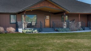 A two-story house with a covered porch, large windows, and a front door.
