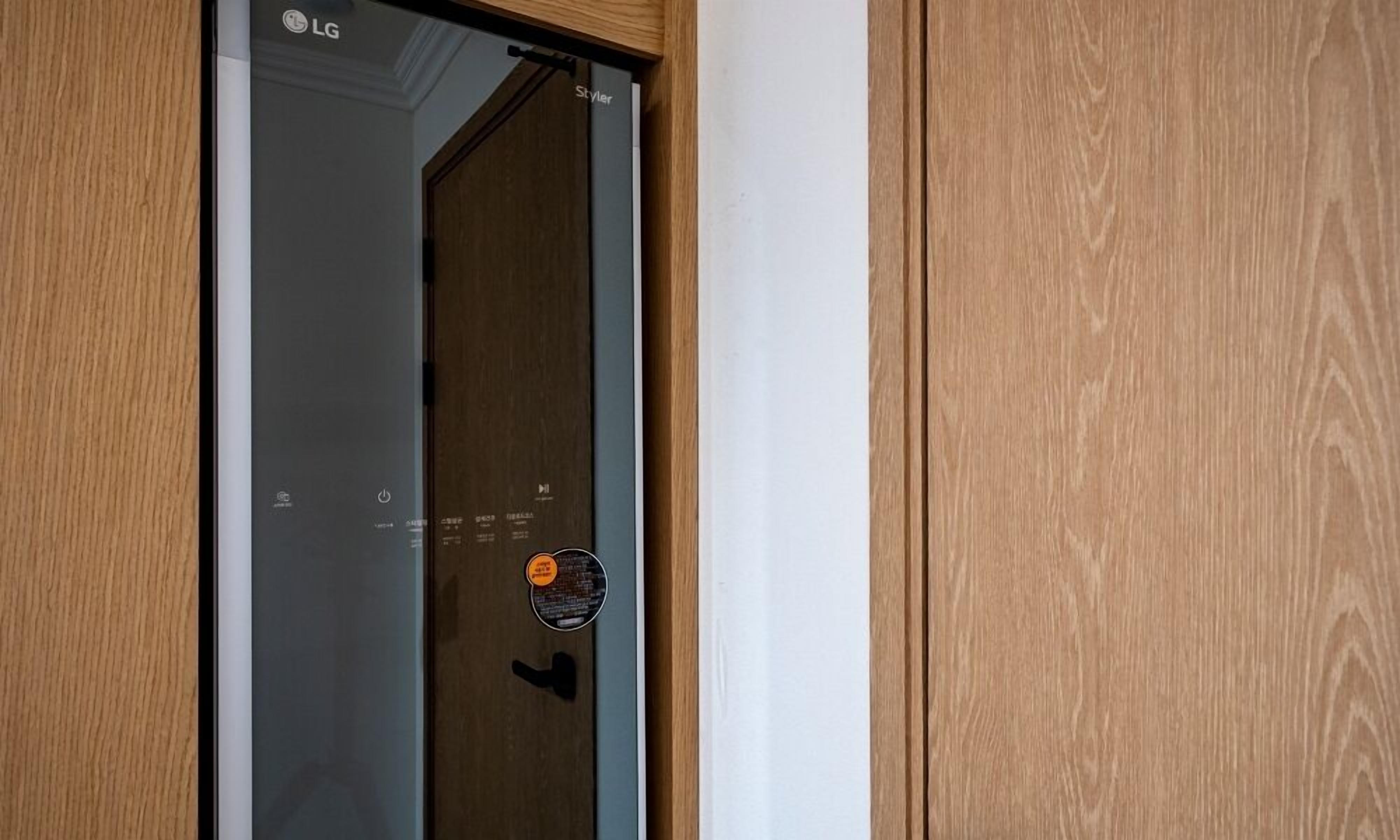Une porte en bois avec un panneau de verre et le logo LG.
