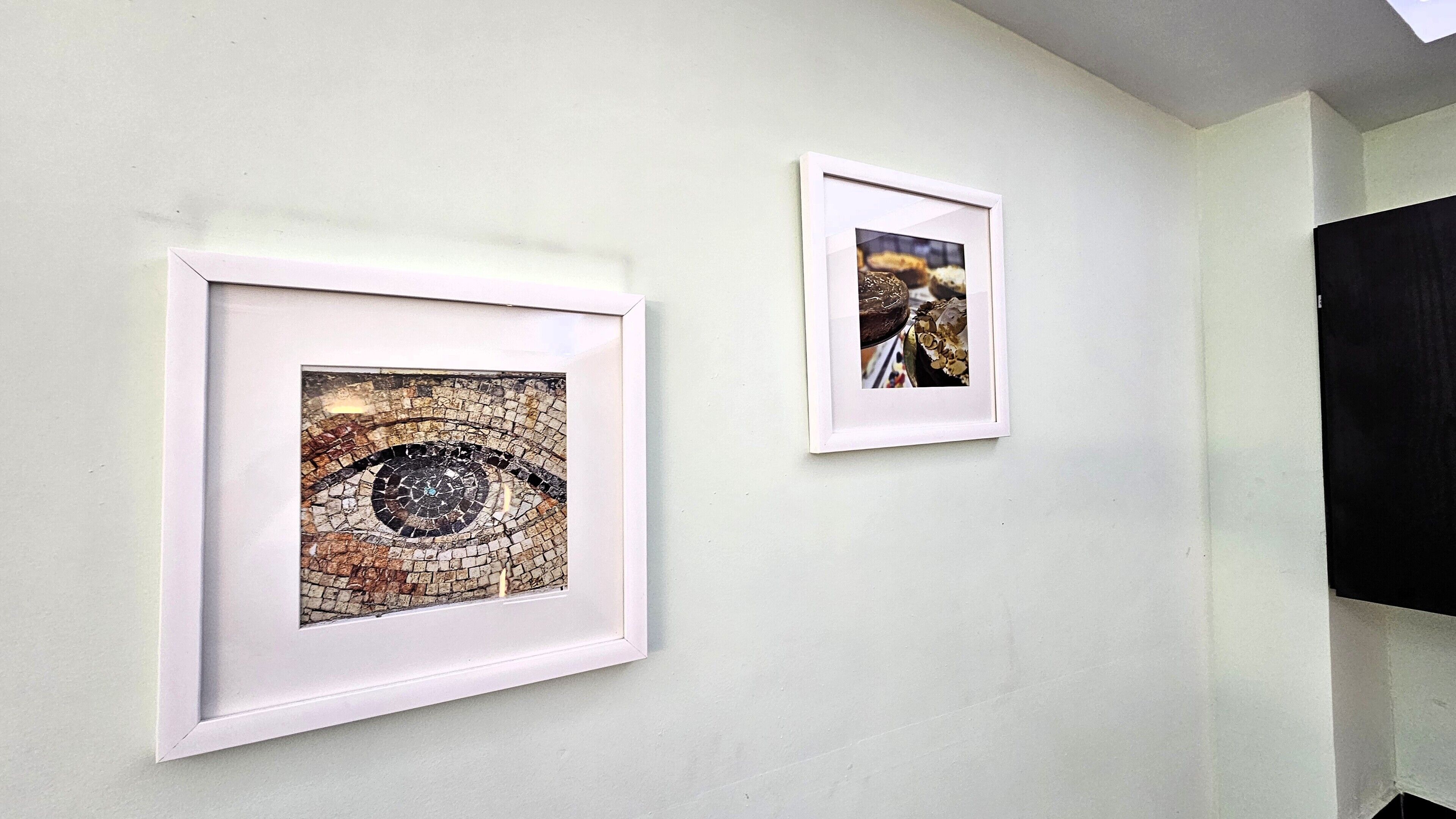 Due opere d'arte incorniciate su un muro spoglio.