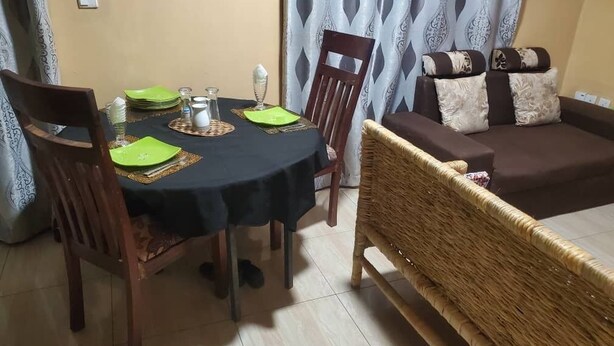 Un comedor con una mesa redonda, sillas y un sofá.