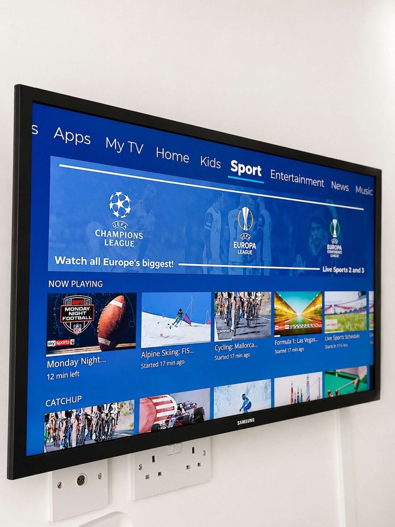 A TV screen displaying a sports channel interface with options for apps, TV, home, kids, sport, entertainment, news, and music.