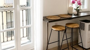 Una cocina con barra, una ventana con cortinas y un electrodoméstico blanco.
