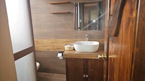 A bathroom with a wooden vanity, a white sink, and a mirror above it. - beautiful and warm apartment,  5 minutes from Cusco airport (Cusco)