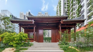 A traditional wooden gate with a tiled roof, leading to a building with a modern urban backdrop. - Wutong Hotel Apartment (Bao'an Center) (Shenzhen)