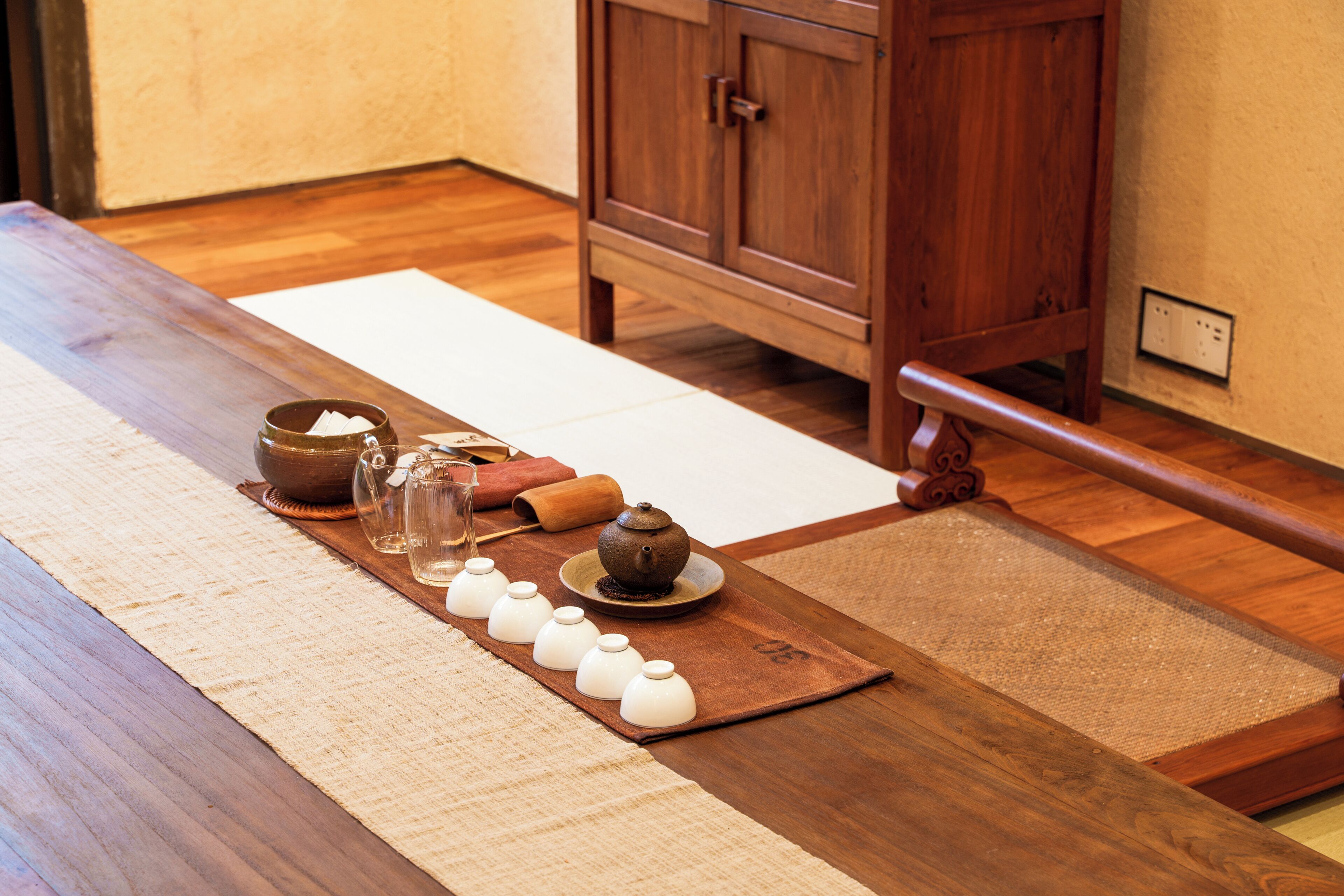 A traditional Japanese tea ceremony setup with a wooden table, tatami mats, and tea utensils.