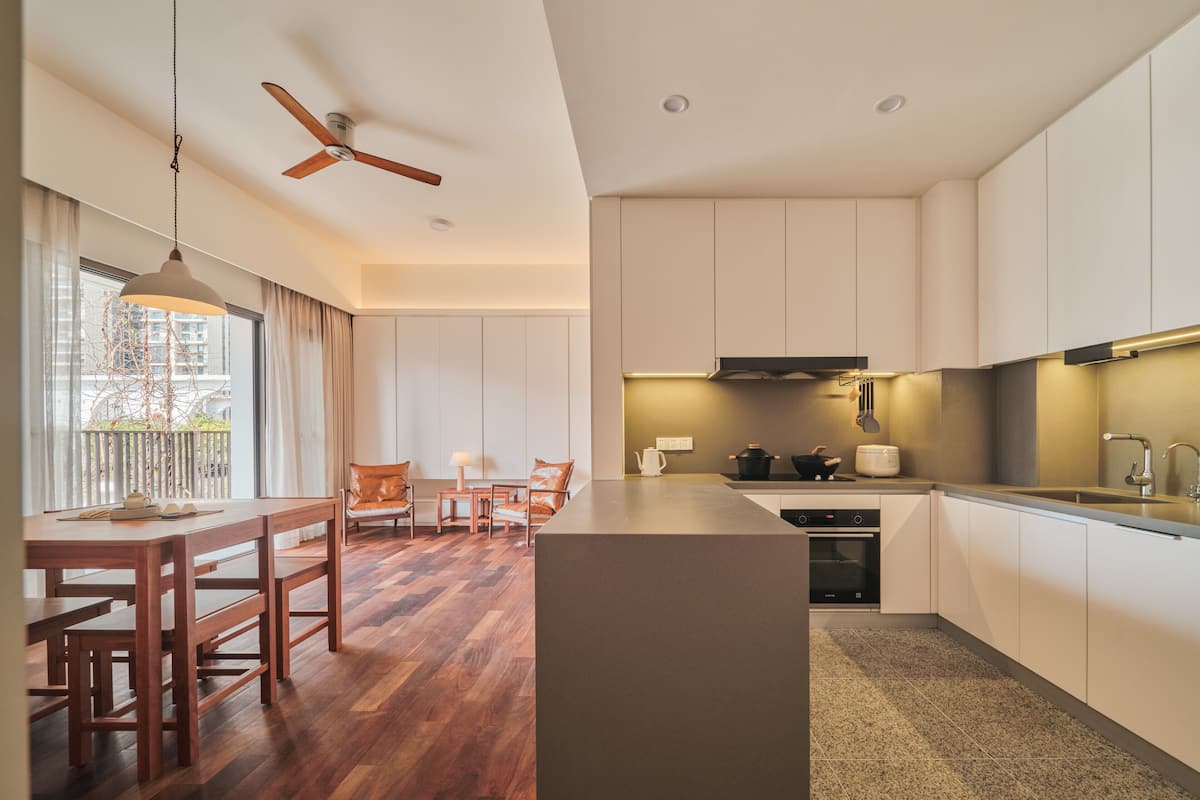 Eine moderne Küche mit Holzboden, einem Essbereich mit Tisch und Stühlen sowie einem Deckenventilator.
