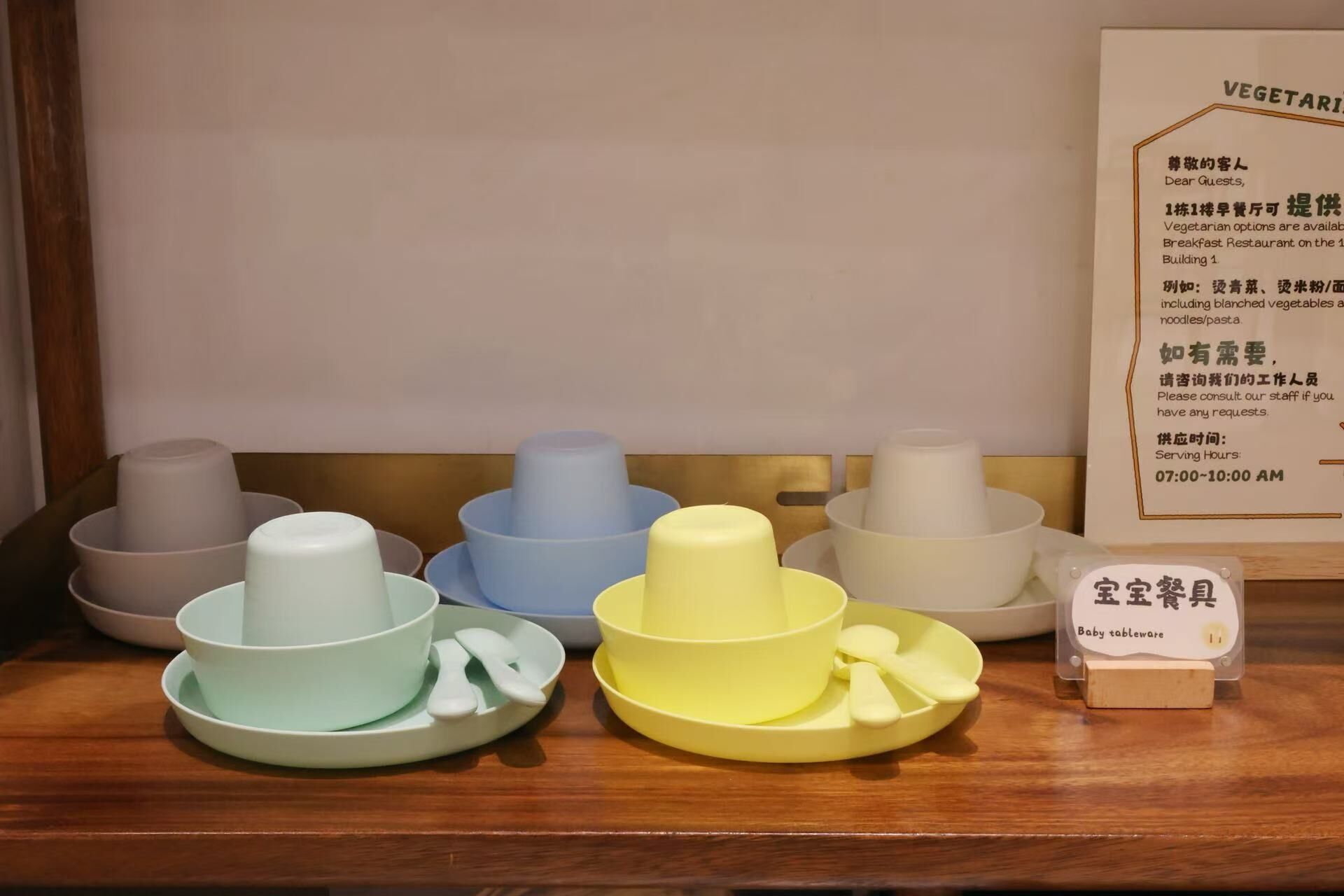 A set of baby tableware on a wooden surface.