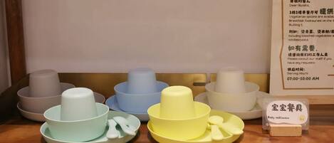 A set of baby tableware on a wooden surface.