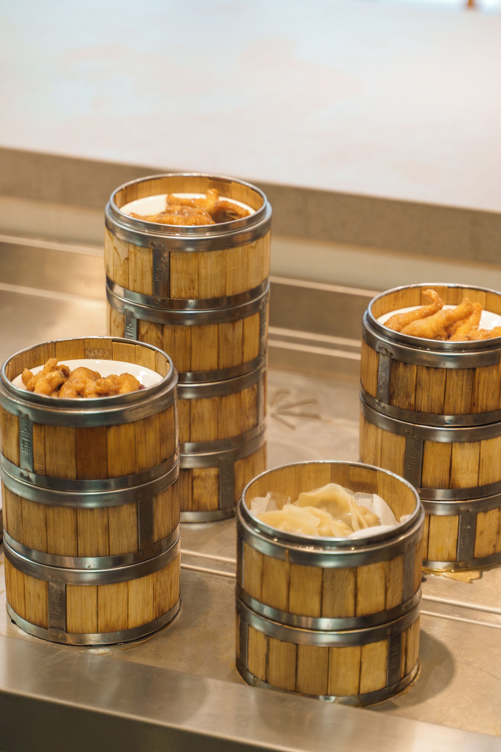 Four wooden barrels with metal bands, each containing different food items.
